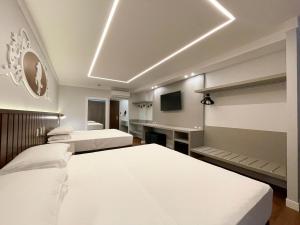 a bedroom with two beds and a tv in it at Fazzenda Park Resort in Gaspar