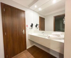 a bathroom with a sink and a large mirror at Fazzenda Park Resort in Gaspar