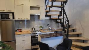 a kitchen with a spiral staircase in a kitchen at Domek u Eli in Solec-Zdrój