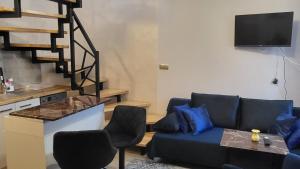 a living room with a blue couch and a kitchen at Domek u Eli in Solec-Zdrój