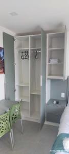 ein Schlafzimmer mit einem Bett und einem Schrank mit Regalen in der Unterkunft Flat 304 Porto Prime com Rooftop e Piscina in Porto De Galinhas + 12 Fotos