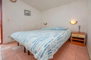 - une petite chambre avec un lit et une table de nuit dans l'établissement Apartments Marinero, à Drage
