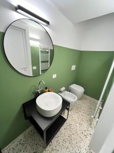 La salle de bains verte est pourvue d'un lavabo et d'un miroir. dans l'établissement Maffi Apartment Galatina, à Galatina