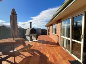 a patio with a table and an umbrella on a deck at Views and Location in Twizel