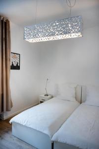 1 dormitorio con 2 camas y lámpara. en Wohngut-City Appartement 3 für max 5 Personen inklusive Parkplatz, en Hagen