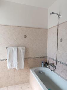 a bathroom with a bath tub and a towel at Villa Magnolia B&B in Taormina
