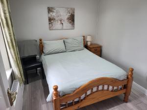 een slaapkamer met een bed met een houten frame bij Peaceful Farm Cottage in Menlough near Mountbellew, Ballinasloe, Athlone & Galway in Galway