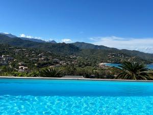 Blick auf einen Pool mit Bergen im Hintergrund in der Unterkunft Villa Pura Corsica with sea view and private pool in Conca
