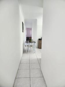 um corredor com paredes brancas e uma mesa e cadeiras em Excelente apartamento centro Paulo Afonso em Paulo Afonso