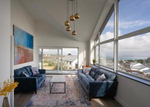 a living room with two couches and large windows at Bay View Villa in Carbis Bay