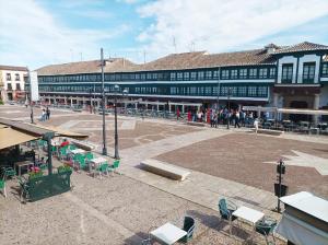 un gran edificio con un patio con mesas y sillas en Plaza Mayor, en Almagro