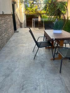 a patio with a wooden table and chairs at WhiteBoxApartment in Kyustendil