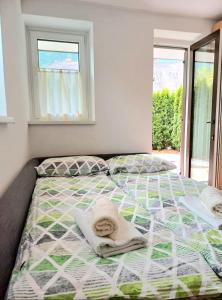 1 dormitorio con 1 cama con toallas en Apartma Kati, en Bovec