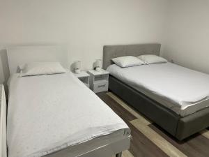 - deux lits jumeaux dans une chambre avec deux tables dans l'établissement Apartman Mila, à Višegrad