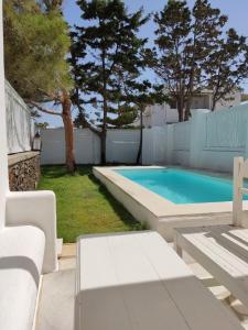 a swimming pool in a backyard with a white fence at Rodi Apartments in Parikia