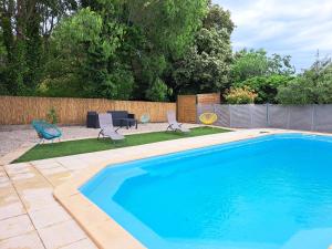 a swimming pool with two chairs and a table and chairs at Villa les fauvettes in Cabasse +11 photos