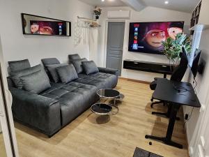 un salon avec un canapé et une télévision à écran plat dans l'établissement Gite à moins de 10 minutes de la cité médiévale de Carcassonne, à Carcassonne