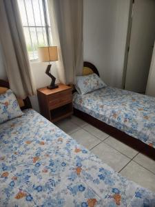um quarto com 2 camas e um candeeiro numa mesa de cabeceira em Excelente apartamento centro Paulo Afonso em Paulo Afonso