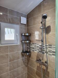 une douche avec une porte vitrée dans une salle de bain dans l'établissement Gite à moins de 10 minutes de la cité médiévale de Carcassonne, à Carcassonne 13 autres photos