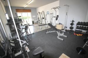 - une salle de sport avec plusieurs tapis de course et machines dans l'établissement Villa Acqua Dolce, à Taurisano