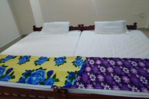 a bed with a blanket on top of it at SPOT ON Sana Tourist Home in Kollam