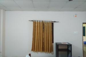 a curtain on the wall of a room at SPOT ON Sana Tourist Home in Kollam