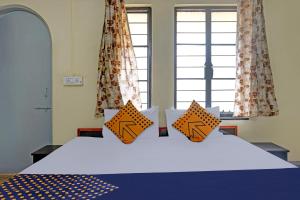 a bedroom with a bed with orange pillows on it at SPOT ON Hotel Prakash Residency, Near Hanuman Gym Ajmera Colony, Pimpri in Chinchwad