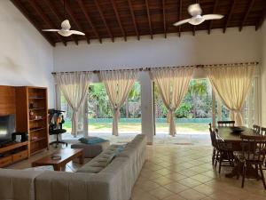 a living room with a couch and a table at Praia de Itamambuca- Casa charmosa e iluminada in Ubatuba