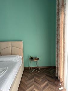 a bedroom with a bed and a small table at Stormi's Apartament in Pogradec +29 photos