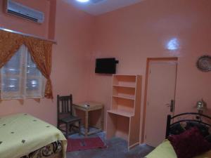 タリオウイネにあるauberge souktanaのベッドルーム(ベッド1台、デスク、テレビ付)