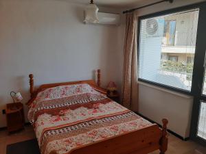 1 dormitorio con cama y ventana grande en Ivanovino Residence en Varna