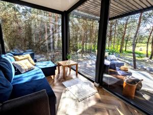 a living room with a large glass window at Przeszklony Tiny House w Lesie in Tomczyn
