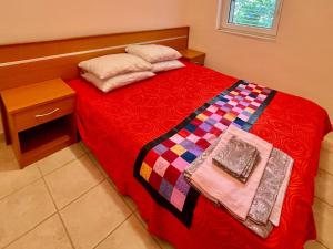 a bedroom with a red bed with a wooden headboard at Boris Apartments in Petrovac na Moru