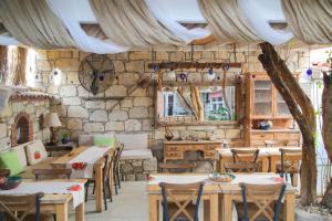 a restaurant with tables and chairs and a stone wall at Filizce Alaçatı in İzmir