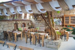 a restaurant with tables and chairs and a tree at Filizce Alaçatı in İzmir