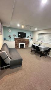 a living room with a couch and a table and a fireplace at Sabrina's Home in Delta
