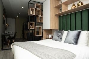 een slaapkamer met een wit bed en een groene muur bij Nuevo loft en Zona T - Cabrera 85 -12 in Bogota