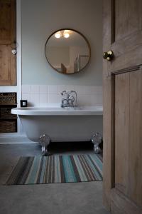 a white tub in a bathroom with a mirror at Chester Townhouse in the City Centre in Chester