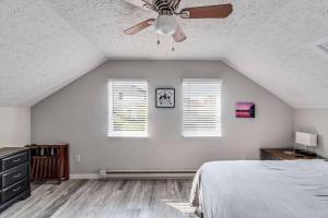 een slaapkamer met een plafondventilator en 2 ramen bij Lake Studio Casita in Akron