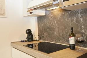 a bottle of wine on a counter with a wine glass at MILANO URBAN FLATS - City Center Apartments in Milan +10 photos