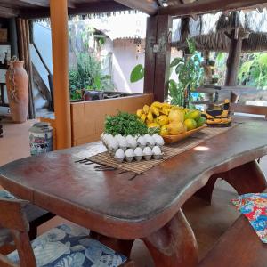 a table with a bowl of fruit and a bowl of eggs at Pousada Bora Bora in Guarapari