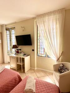 a bedroom with a bed and a desk and a window at Camere Chicca in Sanremo