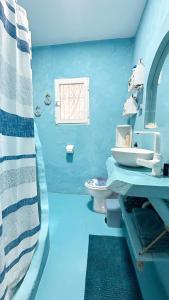 uma casa de banho azul com um lavatório e um WC em Beach house MAREA CORAL em Melilla