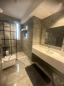 uma casa de banho com um WC, um lavatório e uma banheira em Jamal Royal Apartments em Medina