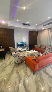 a living room with couches and a flat screen tv at درة العروس فيلا الذهبي 38 in Durat  Alarous