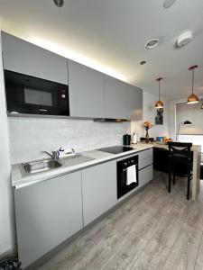 a kitchen with white cabinets and a sink at Stylish Apartment City Centre in Sheffield