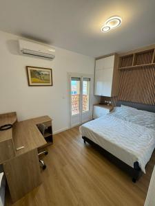 a bedroom with a bed and a desk and a desk at Face à la mer avec clim, wifi, parking in Le Barcarès