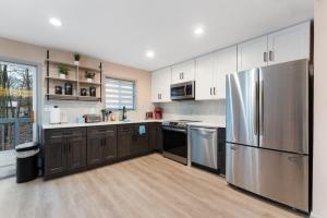 una cocina con nevera de acero inoxidable y armarios de madera en Cozy affordable family place in Poconos home, en East Stroudsburg