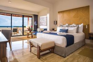 1 dormitorio con 1 cama grande y sala de estar en Dreams Sapphire Resort & Spa, en Puerto Morelos