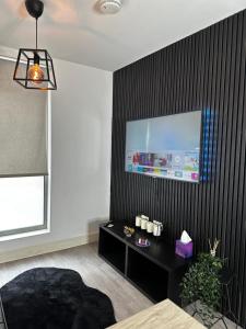 a living room with a black wall with a tv at Stylish Apartment City Centre in Sheffield